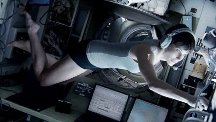 A striking HD wallpaper from the movie Gravity (2013), featuring a floating astronaut in a spacecraft, immersed in a moment of intense concentration amidst advanced technology.