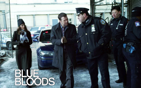 HD PC desktop wallpaper for the TV show Blue Bloods: uniformed NYPD officers converse by squad cars in a snowy gated lot, series logo in the lower-left.