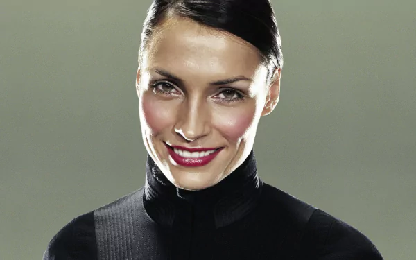 HD desktop wallpaper of Dutch actress Famke Janssen smiling in a black turtleneck against a neutral background.