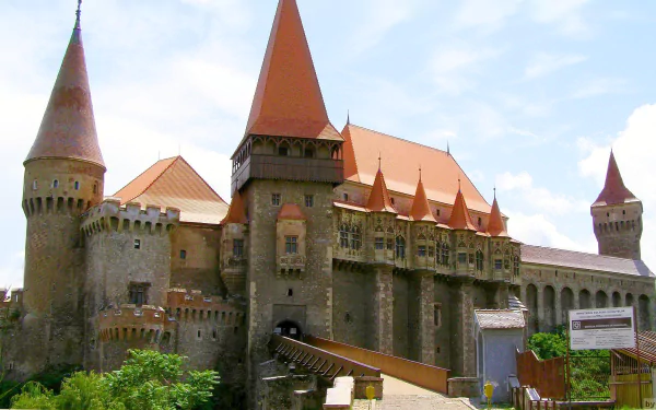 HD PC desktop wallpaper showcasing the man-made historic Corvin Castle with its towering spires and detailed stone architecture under a bright sky.