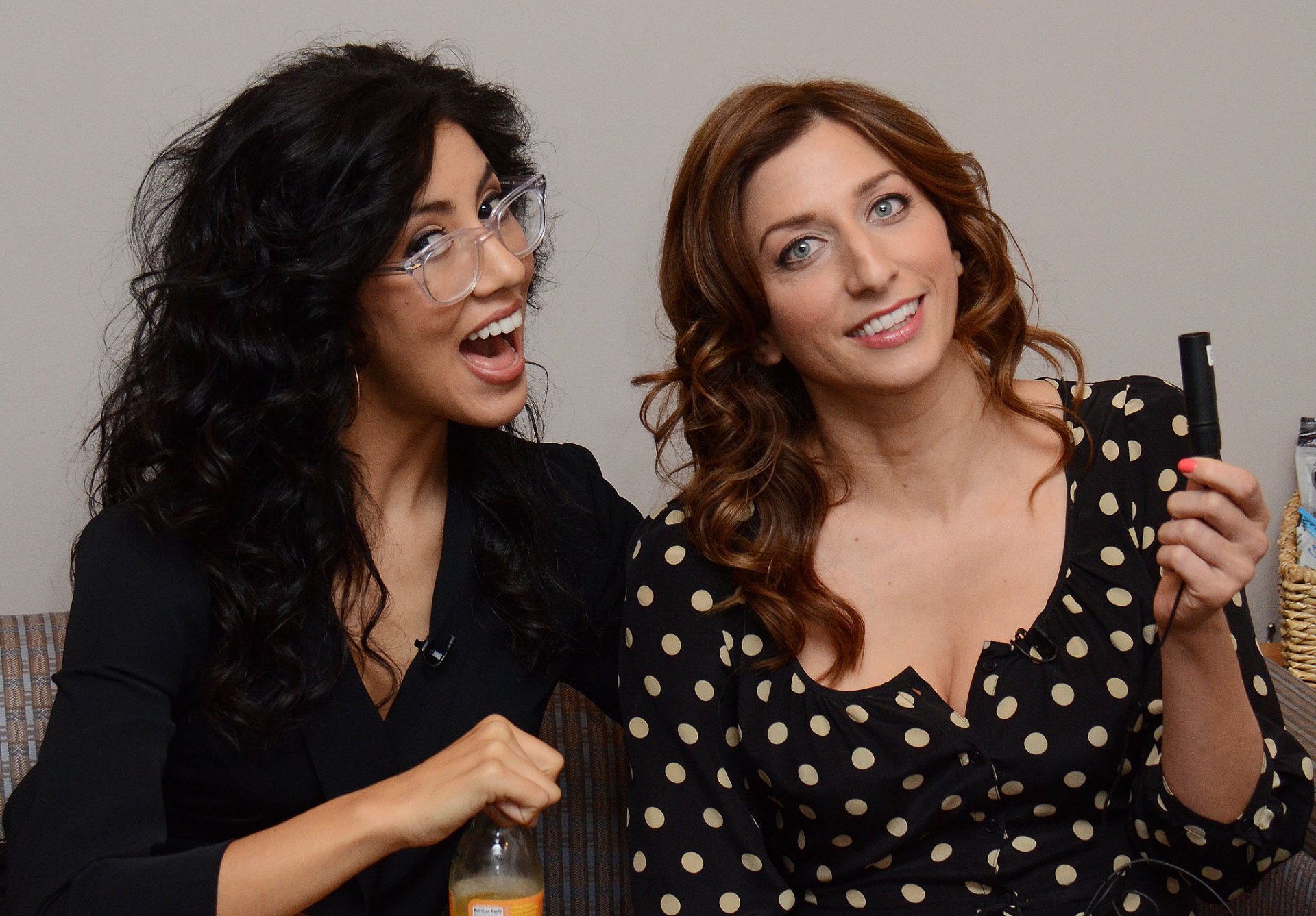 HD wallpaper featuring two women smiling and posing playfully for the camera, one holding a marker.