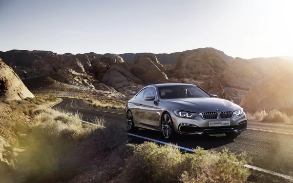 A sleek BMW Concept 4 Series Coupé parked on a rocky desert road, captured in this HD PC desktop wallpaper showcasing the vehicle’s elegant design.