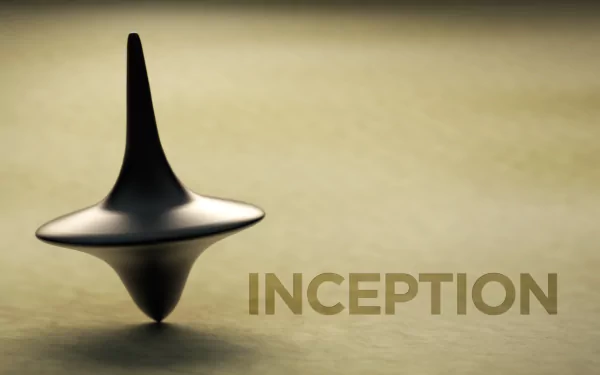 HD wallpaper featuring the spinning top from the movie *Inception*, symbolizing the blurred lines of reality and dreams, with the title INCEPTION prominently displayed.