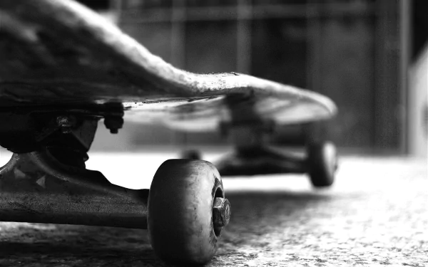 A low-angle view of a skateboard on the ground, capturing the details of the wheels and deck. This 4K Ultra HD wallpaper showcases the essence of skateboarding and sports.