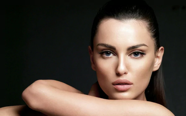 Close-up HD desktop wallpaper of woman Catrinel Menghia with a serious expression against a dark background.