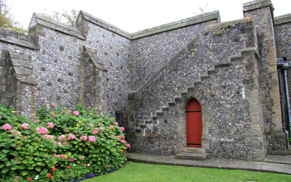 Man-made stone staircase and red door at Arundel Castle framed by hydrangeas and lawn — HD PC desktop wallpaper/background.