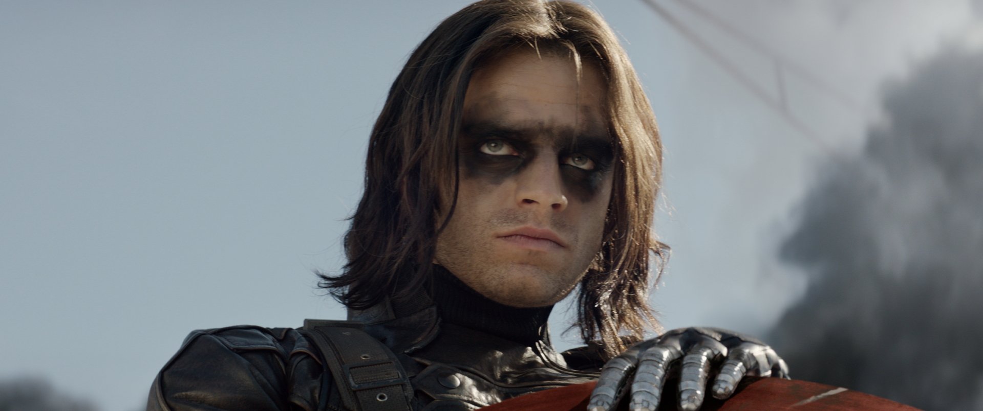 Sebastian Stan as the Winter Soldier, showcasing his intense gaze and iconic look from the movie Captain America: The Winter Soldier in a striking HD desktop wallpaper.