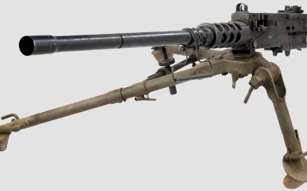 High-definition image of a machine gun set against a neutral background, showcasing its intricate details and man-made design, suitable as a striking desktop wallpaper.