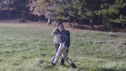 HD desktop wallpaper featuring two characters walking in a grassy field from the TV show The Walking Dead.