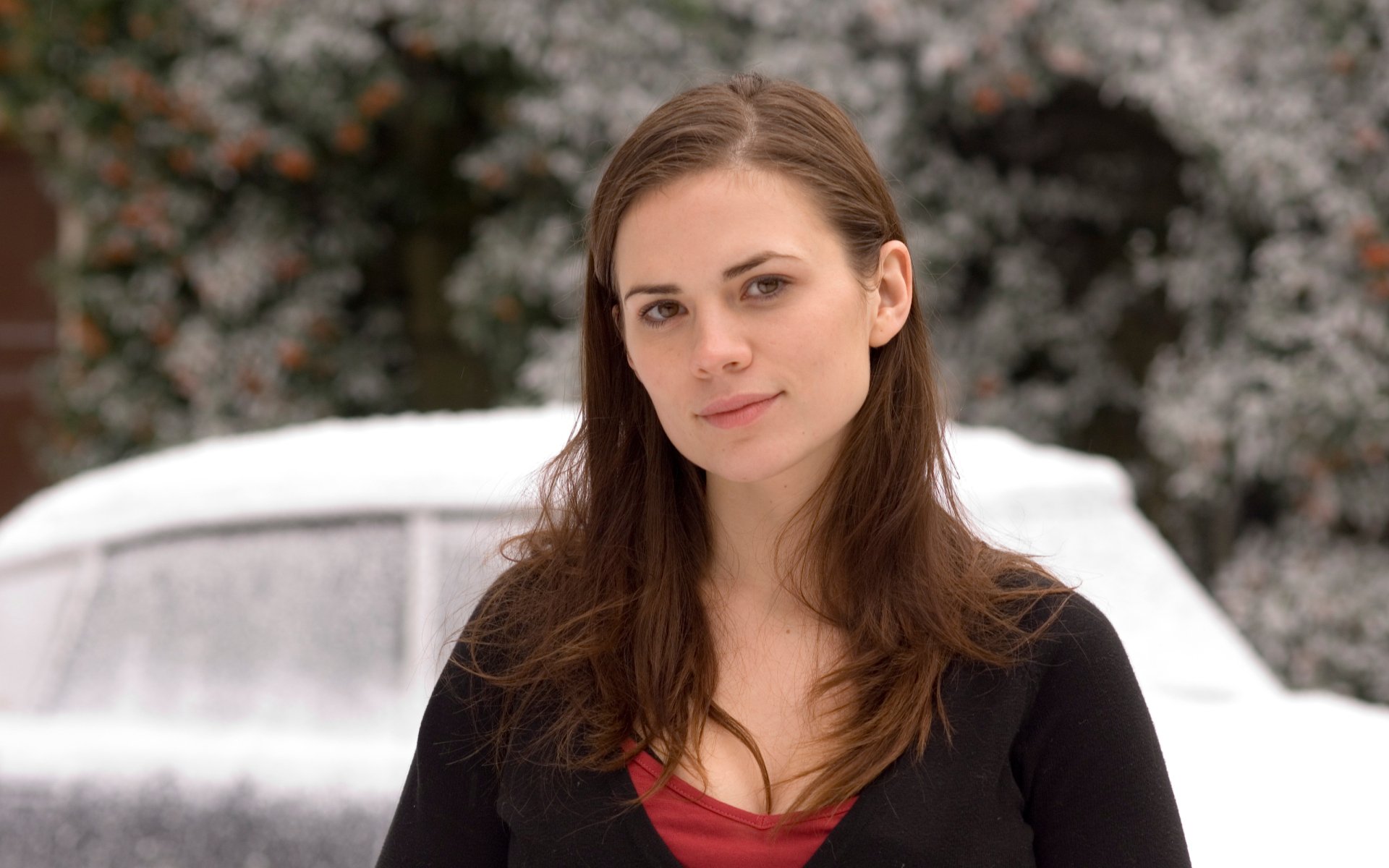 HD desktop wallpaper featuring English actress and celebrity Hayley Atwell standing outdoors with a snowy background.