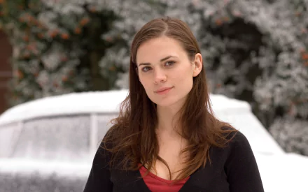 HD desktop wallpaper featuring English actress and celebrity Hayley Atwell standing outdoors with a snowy background.