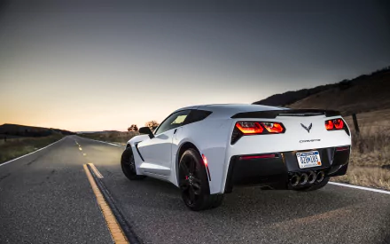 HD PC desktop wallpaper featuring a white Chevrolet Corvette Stingray Coupe parked on an empty road at dusk.