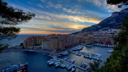 Monaco cityscape and man-made marina captured as a 2K Quad HD PC desktop wallpaper: yachts in harbor, coastal high-rises beneath a dramatic sunset.