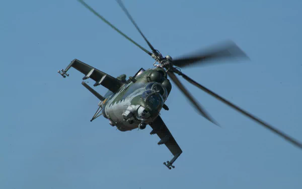 Close-up view of a military Mil Mi-24 helicopter in flight against a clear blue sky, captured in 4K Ultra HD quality for desktop wallpaper.