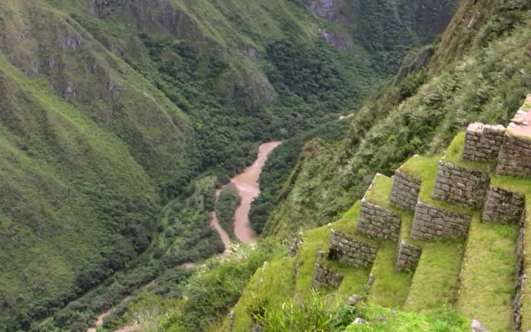 HD desktop wallpaper showcasing the man-made terraces of Machu Picchu overlooking a winding river through lush green mountains.
