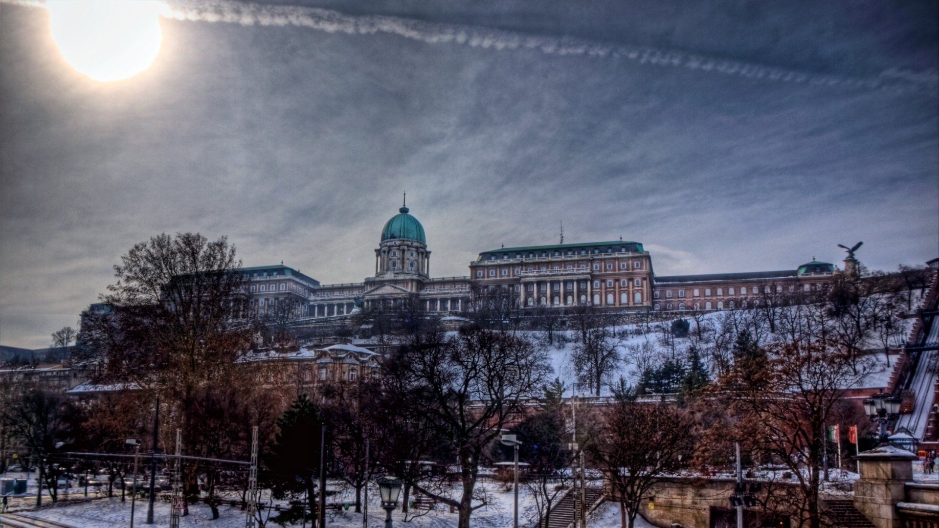 HD PC desktop wallpaper featuring a man-made view of Buda Castle under a partly cloudy sky with trees in the foreground.