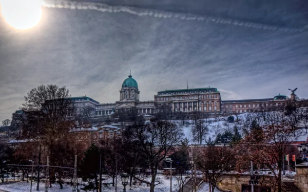 HD PC desktop wallpaper featuring a man-made view of Buda Castle under a partly cloudy sky with trees in the foreground.