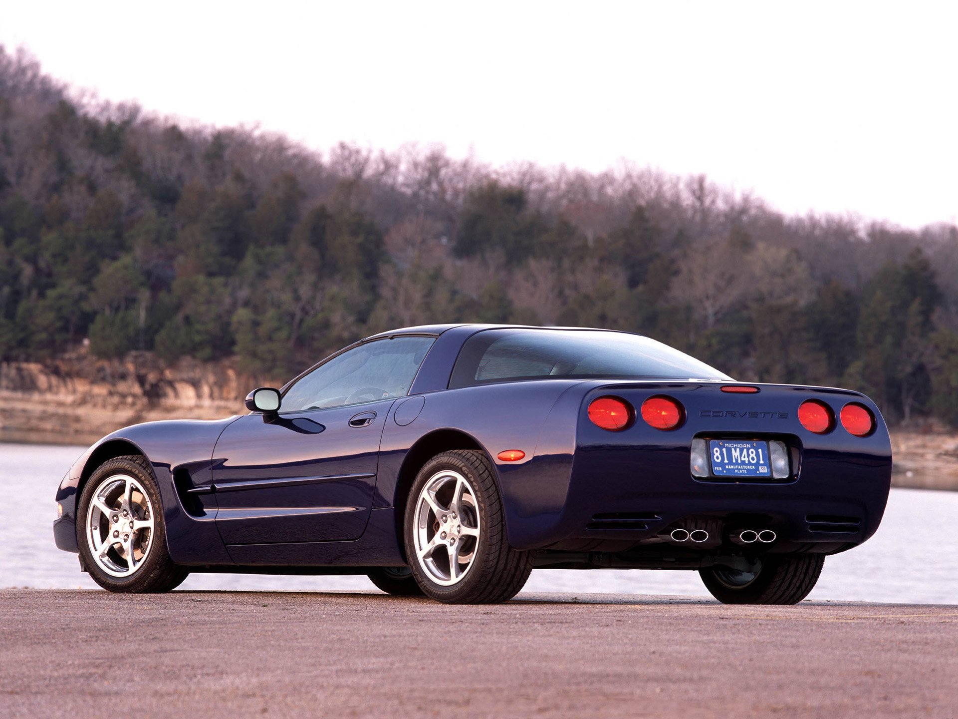 Rear three-quarter view of a blue Chevrolet Corvette (C5) parked by a lakeshore, HD PC desktop wallpaper/background.