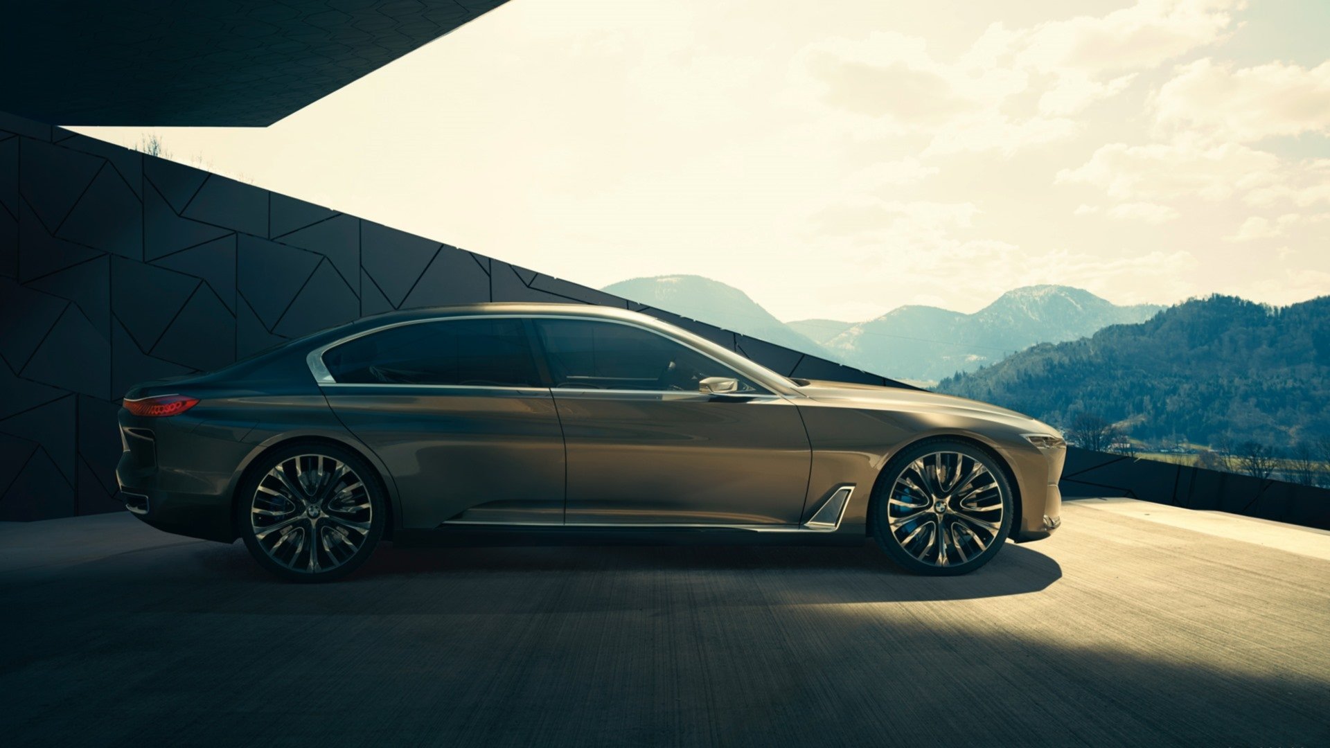 Side profile of a sleek 2014 BMW Vision Future Luxury concept vehicle against a mountainous backdrop, featured as an HD PC desktop wallpaper.