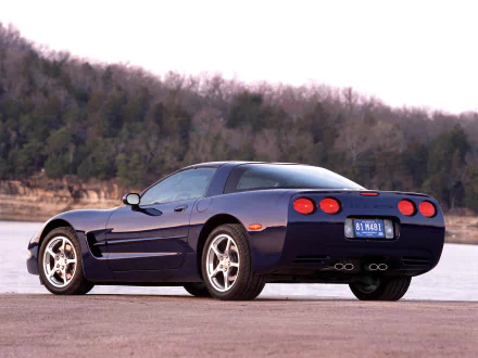 Rear three-quarter view of a blue Chevrolet Corvette (C5) parked by a lakeshore, HD PC desktop wallpaper/background.