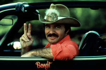 HD PC desktop wallpaper featuring a scene from the movie Smokey and the Bandit with the main character flashing a peace sign from a car window.