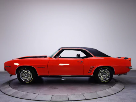 HD PC desktop wallpaper: side profile of a red Chevrolet Camaro Z28 RS vehicle on a studio turntable against a neutral background.