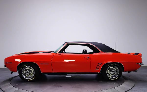HD PC desktop wallpaper: side profile of a red Chevrolet Camaro Z28 RS vehicle on a studio turntable against a neutral background.