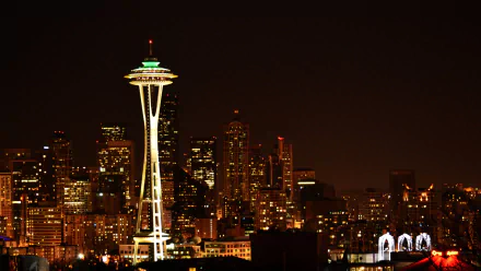 Nighttime view of Seattle’s illuminated Space Needle and surrounding city skyline, captured as a high-definition desktop wallpaper.