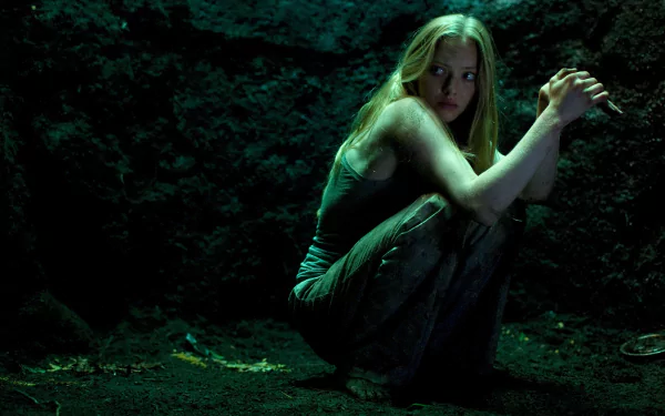 4K Ultra HD PC desktop wallpaper: a tense female lead crouches in a shadowy, mossy cave, clutching her arms — cinematic still from the movie Gone.