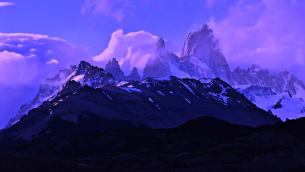 HD desktop wallpaper showcasing Mount Fitz Roy towering above a dark mountain range under a vibrant purple sky in a stunning nature scene.