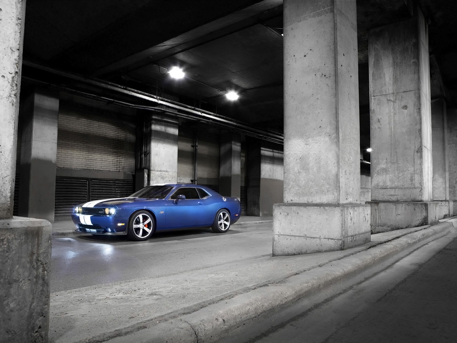 Blue Dodge Challenger SRT8 muscle vehicle in a concrete underpass, HD PC desktop wallpaper background with headlights glowing.