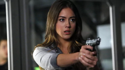 Chloe Bennet as Daisy Johnson from Marvel's Agents of S.H.I.E.L.D. holds a gun, showcasing a tense moment in this high-definition desktop wallpaper.