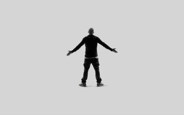 A silhouette of a man with arms outstretched, set against a minimalist background, serves as a striking HD desktop wallpaper celebrating the essence of music, inspired by Eminem.