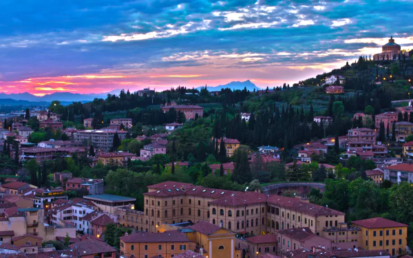 HD desktop wallpaper showcasing a panoramic view of man-made buildings and lush greenery in Verona under a vibrant twilight sky.