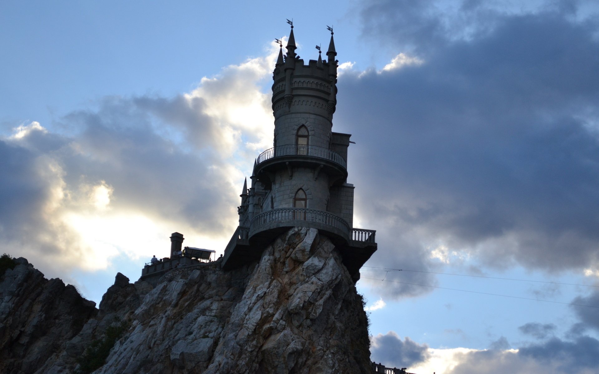 Swallow's Nest, a man-made castle perched on a cliff overlooking the sea in Yalta, Russia, captured against a dramatic cloudy sky.