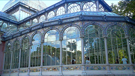 Man-made Palacio de Cristal — HD PC desktop wallpaper/background showing ornate iron-and-glass pavilion with arched windows reflecting trees and sky