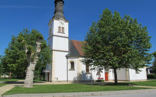 Religious church with white tower and red roof framed by leafy trees under a clear blue sky — 4K Ultra HD PC desktop wallpaper/background.