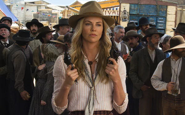 Charlize Theron in a Western outfit holding pistols, set in a crowded town scene from the movie A Million Ways to Die in the West, presented as an HD PC desktop wallpaper.