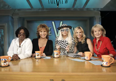 HD desktop wallpaper of 'The View' with hosts seated around the table, coffee mugs in front, on a set backdrop.