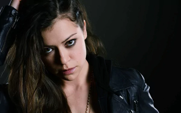 HD PC desktop wallpaper featuring a dark, intense portrait from the TV show Orphan Black, highlighting a character with piercing eyes and a leather jacket against a black background.