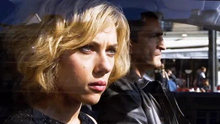 HD desktop wallpaper featuring Scarlett Johansson in a scene from the movie Lucy, highlighting her intense expression and cinematic lighting.