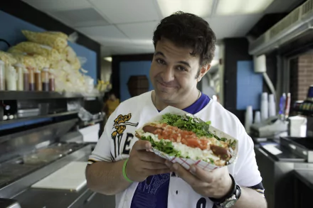 HD desktop wallpaper of Man v. Food featuring a man holding a large sandwich with a delighted expression.