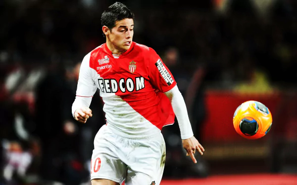 HD desktop wallpaper of James Rodriguez in action on the soccer field, focused on controlling a mid-air ball.