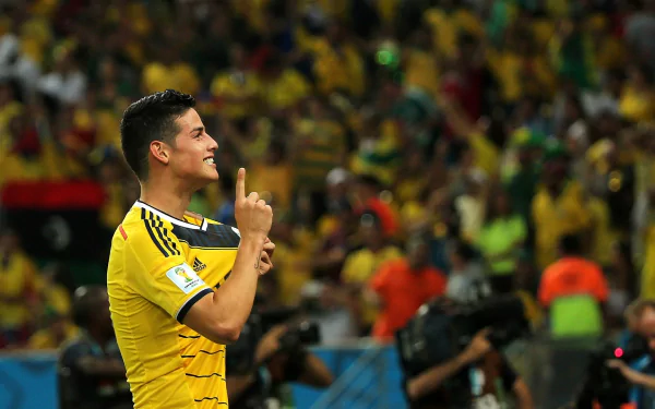 HD desktop wallpaper featuring a football player in a yellow kit celebrating with a crowd in the background.