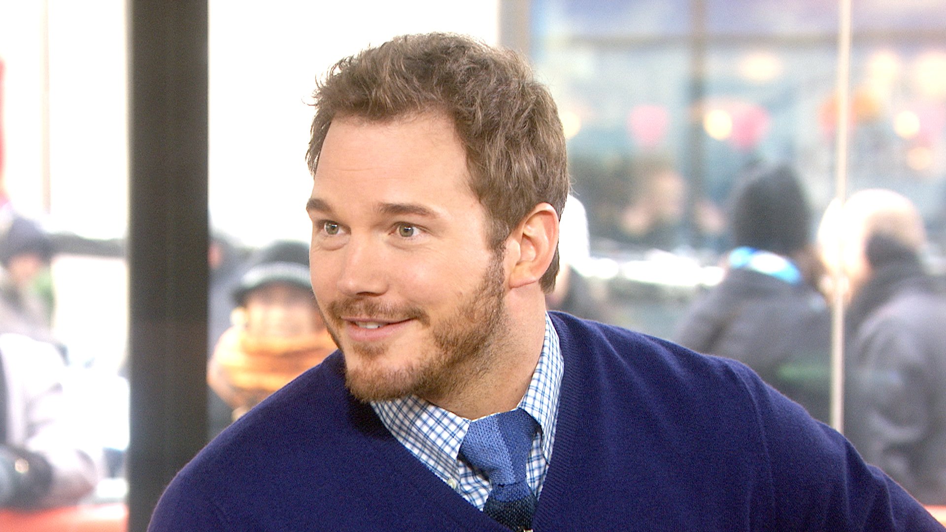 HD wallpaper featuring a smiling person in a blue sweater, suitable as a desktop background.