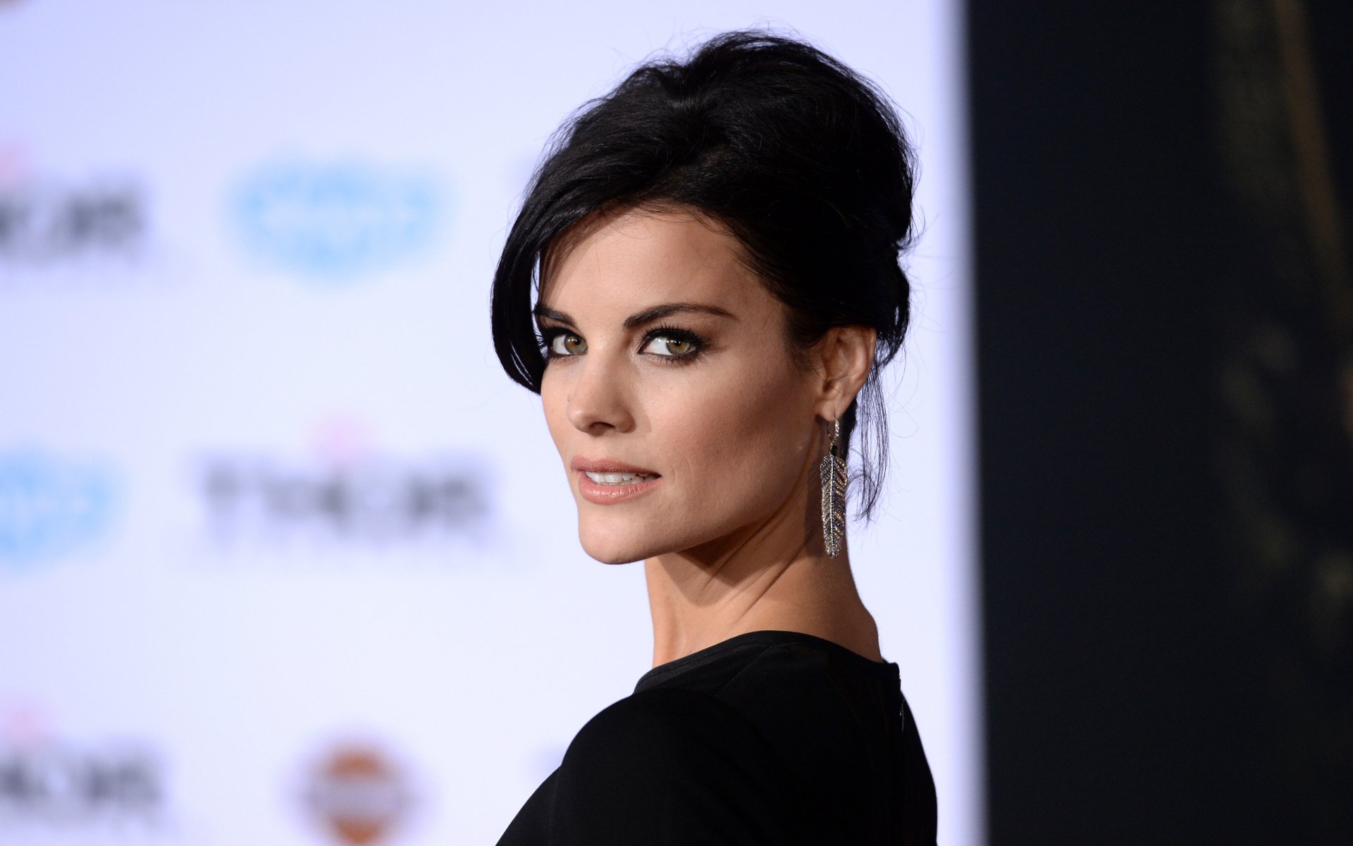 HD PC desktop wallpaper featuring American actress and celebrity Jaimie Alexander in a stylish black outfit against a softly blurred background.