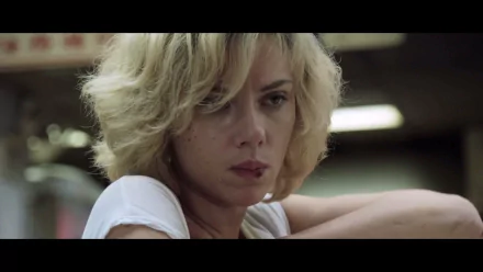 HD desktop wallpaper featuring Scarlett Johansson from the movie Lucy, showcasing a close-up of her intense, blonde-haired character.