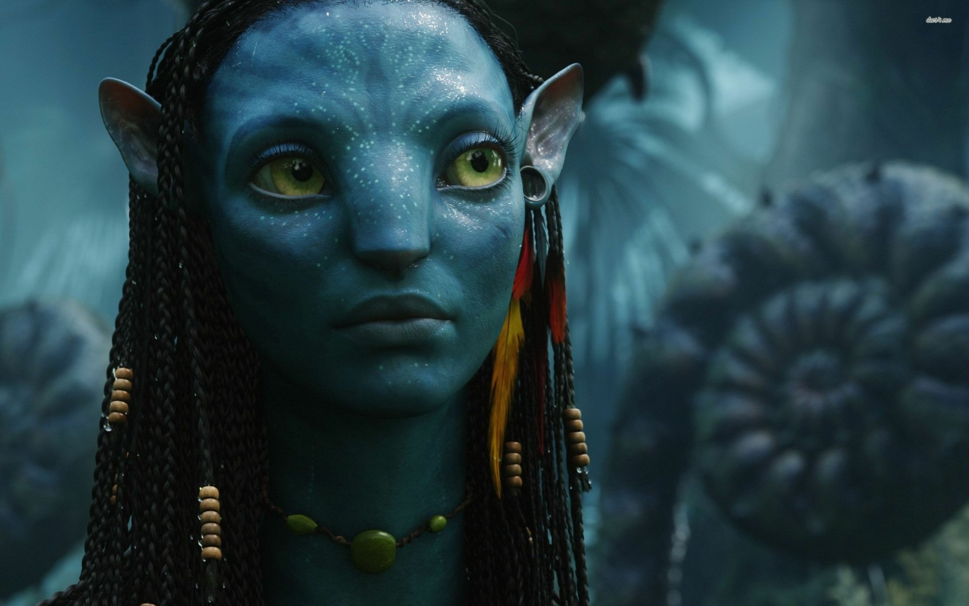 HD PC desktop wallpaper featuring a close-up of a blue Na'vi character from the movie Avatar in a lush, mystical forest setting.