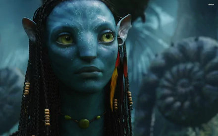 HD PC desktop wallpaper featuring a close-up of a blue Na'vi character from the movie Avatar in a lush, mystical forest setting.