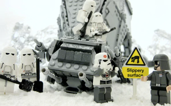HD PC desktop wallpaper featuring LEGO Snowtrooper figures in a war scene from Star Wars, set against a snowy, man-made environment with a Slippery surface warning sign.